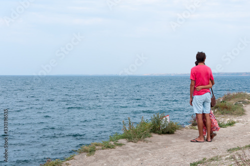 - Loving couple on the seashore looks into the distance. © Oksana Maslova