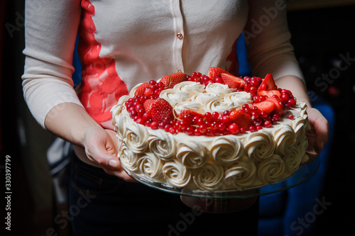 Close-up of pastry chef or baker in apron presenting  freshly baked cake. image for bakeries, confectioneries, food blogs, celebrating special occasions like birthday, wedding,  anniversaries