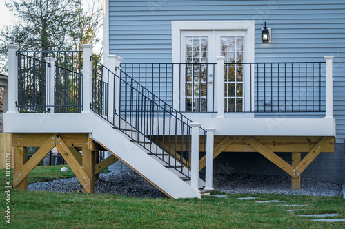 Tablou canvas View of a classic backyard wooden deck with black metal balustrades railing and