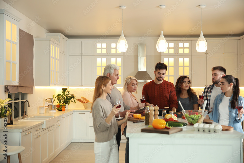 Happy people cooking food together in kitchen Happy people cooking food together in kitchen