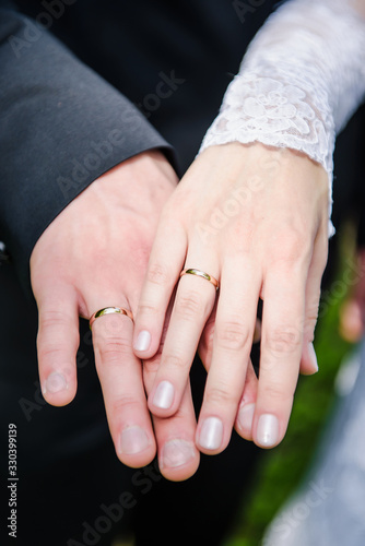 Bride and groom holding hands with wedding rings a nice manicure neat. Just married couple 