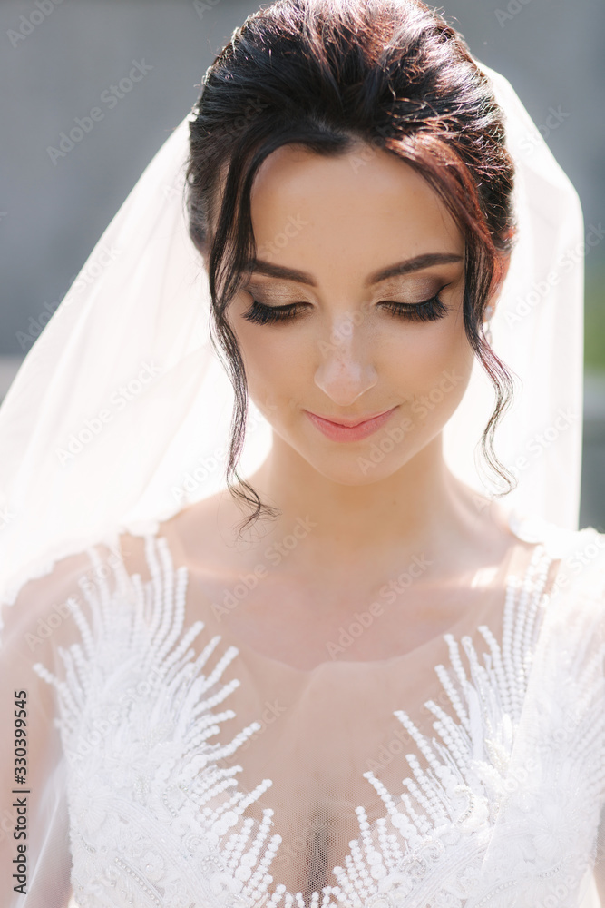 Gorgeous bride in elegant wedding dress with bouquet of white flowers in her wedding day Gorgeous bride in elegant wedding dress with bouquet of white flowers in her wedding day
