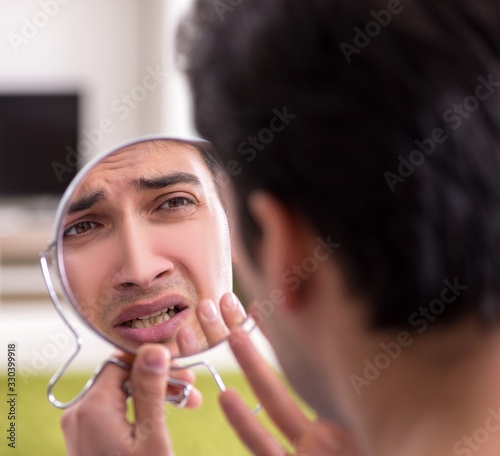Man panicking because of pimples on the skin
