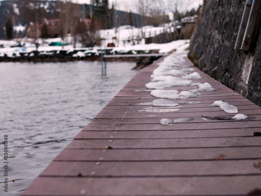 Light snow on a wooden dock at the Lake Joux or Lac de Joux in Switzerland.