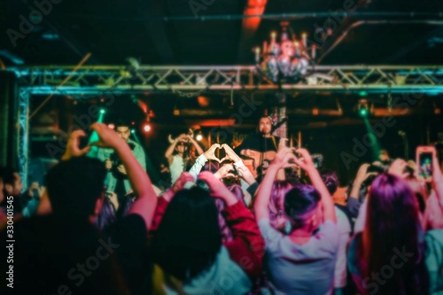 Concert crowd holding up heart shaped hands