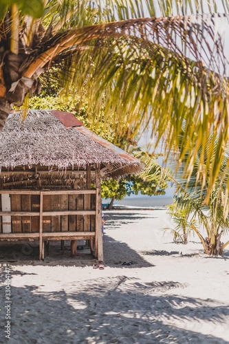 Obraz na plátně Vertical shot of a small hut under a tree on the beach