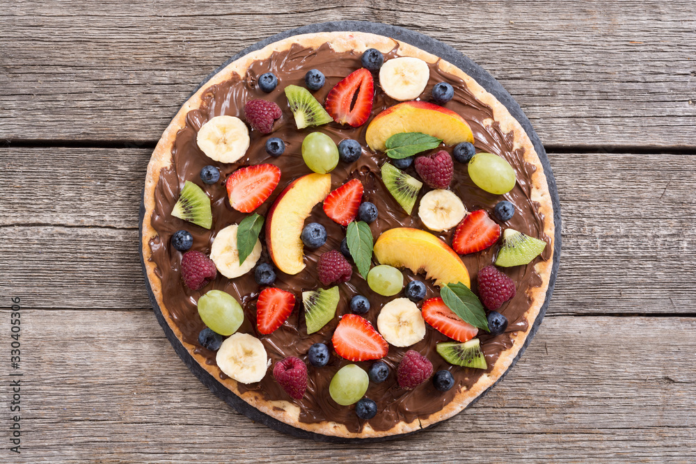 Fruit pizza with nut nougat cream , fruit and berries