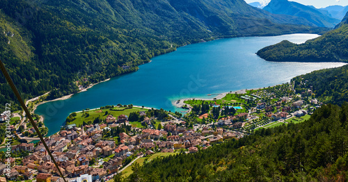 Aerial view over the beautiful Molveno town and Molveno lake, an alpine lake in Trentino, Italy