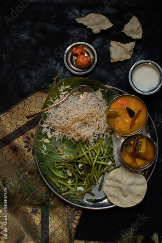 South Indian vegetarian thali consisiting of rice, sambar, rasam, green beans, papad, yougurt photo