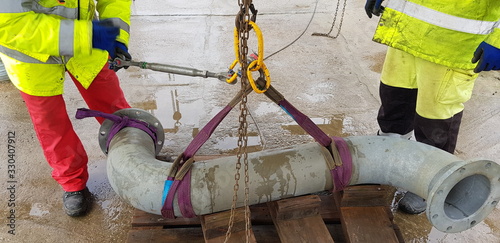 Photos riggers move the pipe using two chain blocks