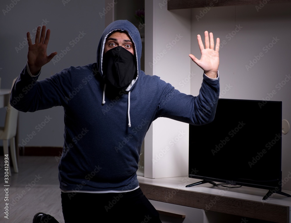 Naklejka premium Burglar thief stealing tv from apartment house