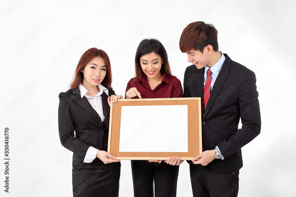 Young attractive one man two woman business office white background holding pointing blank writing board text copy space Young attractive one man two woman business office white background holding pointing blank writing board text copy space