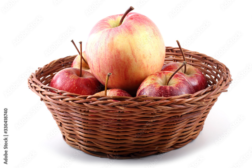 Big and little apples on wicker plate