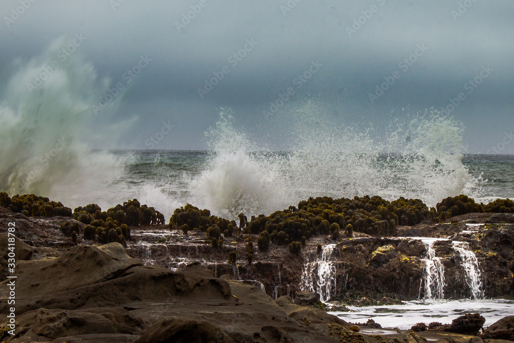 Waves crashing over rocks on the California coast.