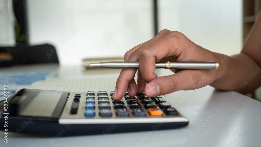 hand of using calculator to calcutate finance for business growth. hand of using calculator to calcutate finance for business growth.