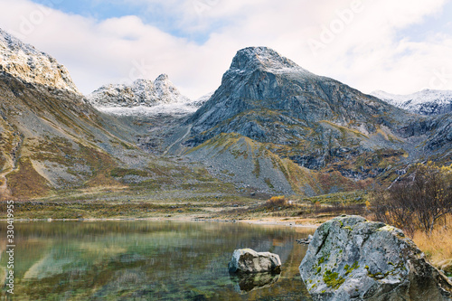 Norwegian fjord beach with snow capped mountains and turquoise arctic ocean water photo