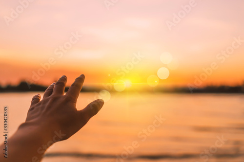 Woman hands reach out to the sky like praying in front of sky.