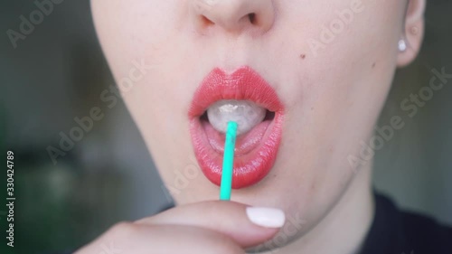 Sexy girl eating a lollipop. female sexy lips suck off a round lollipop.