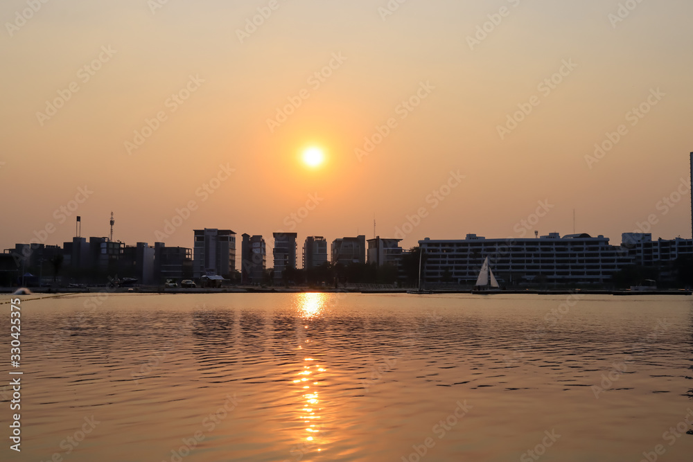 CItyscape modern apartment building near a lake under sunset twilight with cloud sky background with water reflections for background.
