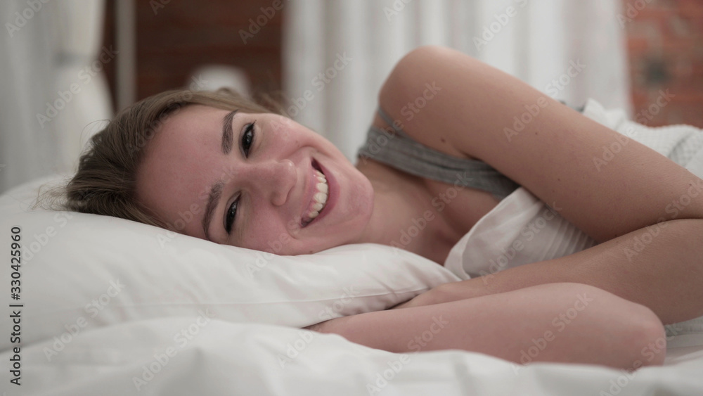 Close Up of Young Woman Smiling at Camera in Bed Close Up of Young Woman Smiling at Camera in Bed