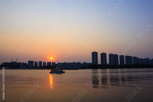 CItyscape modern apartment building near a lake under sunset twilight with cloud sky background with water reflections for background.