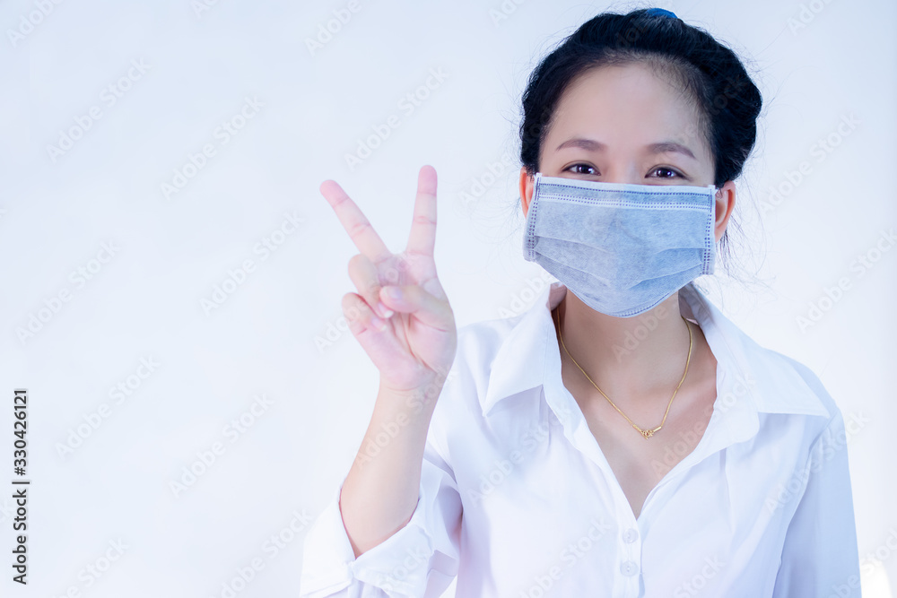 women wear masks ,Ready to use your hand to make a symbol to fight the virus.Corona virus, or Covid-19, is spreading all over the world. women wear masks ,Ready to use your hand to make a symbol to fight the virus.Corona virus, or Covid-19, is spreading all over the world.