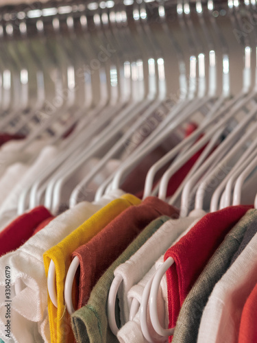 Many hangers with different clothes in the store