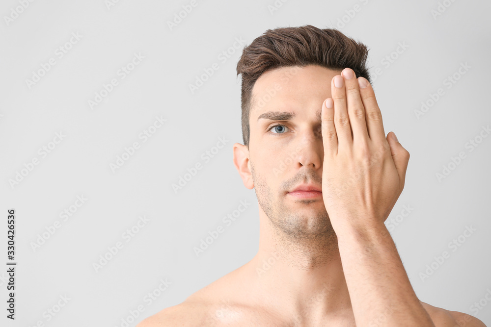 Handsome young man on light background. Plastic surgery concept Handsome young man on light background. Plastic surgery concept