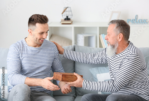Senior man giving a box wit...
