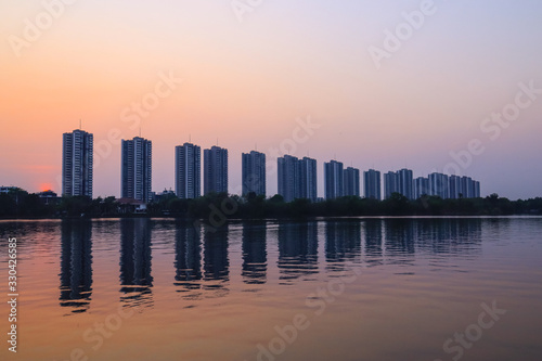 CItyscape modern apartment building near a lake under sunset twilight with cloud sky background with water reflections for background.