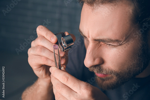 Jeweler examining gemstone ...