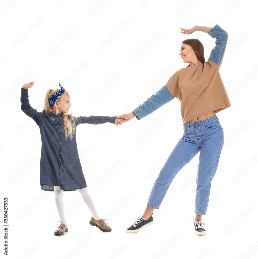 Fototapeta premium Woman and her little daughter dancing against white background