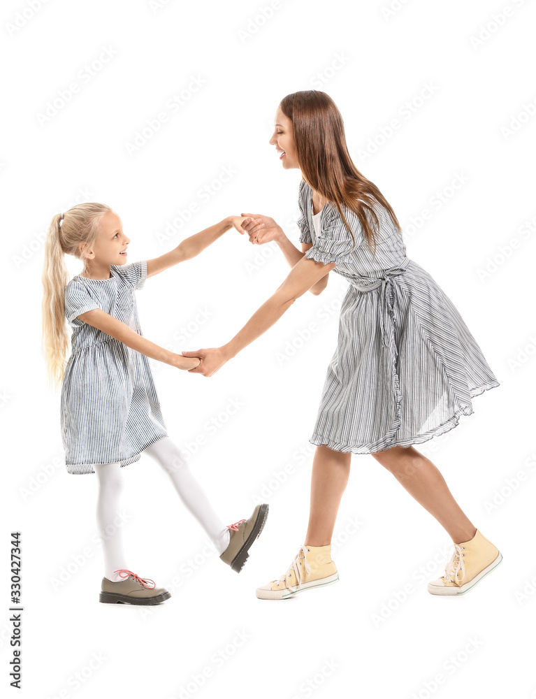 Woman and her little daughter dancing against white background Woman and her little daughter dancing against white background