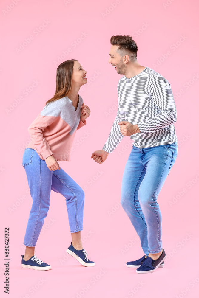 Happy couple dancing against color background Happy couple dancing against color background