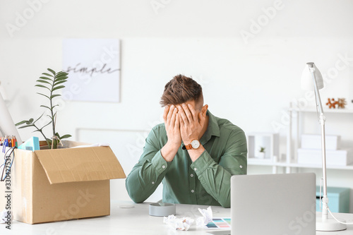 Sad fired man sitting at ta...