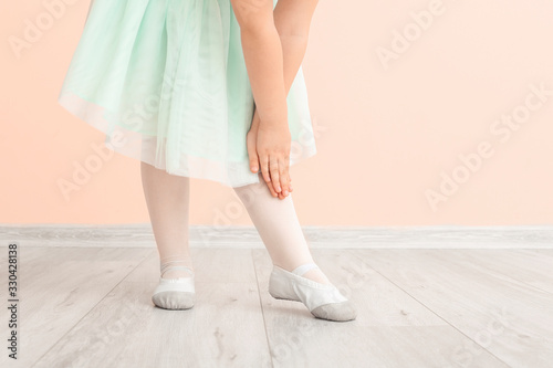 Cute little ballerina near color wall