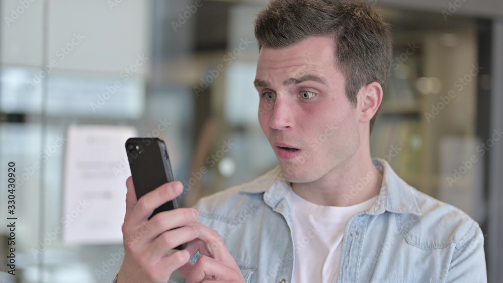 The Portrait of Sad Young Designer getting Loss on Smartphone The Portrait of Sad Young Designer getting Loss on Smartphone