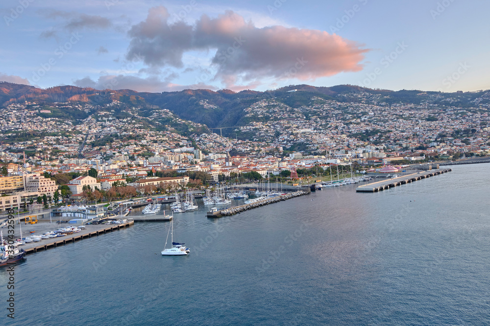 Scenic view of Funchal - capital of Portugal's Autonomous Region of Madeira. Beautiful summer sunny look of small town on hills on paradise tropical island in Atlantic ocean.