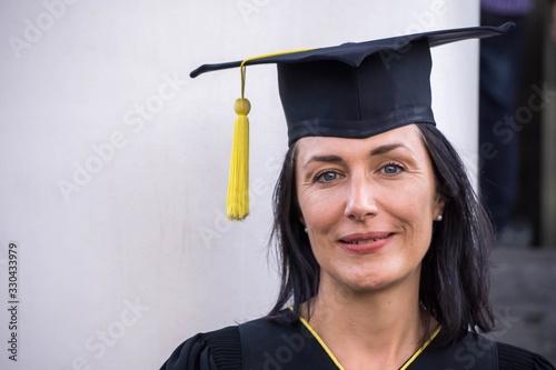 Portrait of happy senior graduate woman in graduation cap on her graduation day.
Middle age.