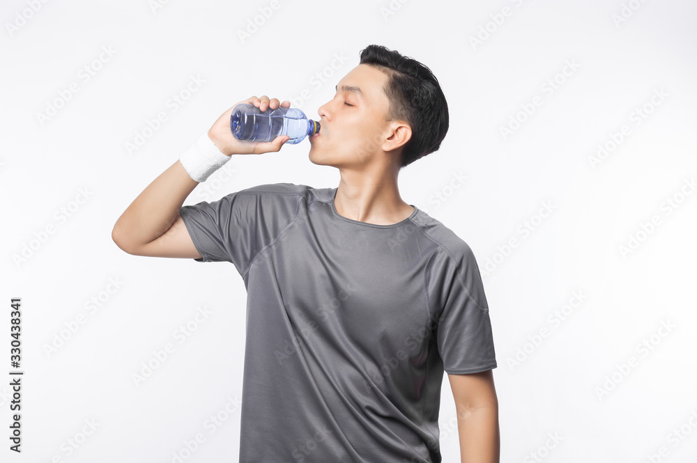 Young asian man in sport outfits drinking water with happy face isolated on white background. Young asian man in sport outfits drinking water with happy face isolated on white background.