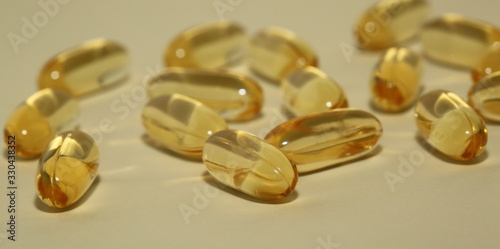 yellow vitamin omega 3 capsules on pastel background