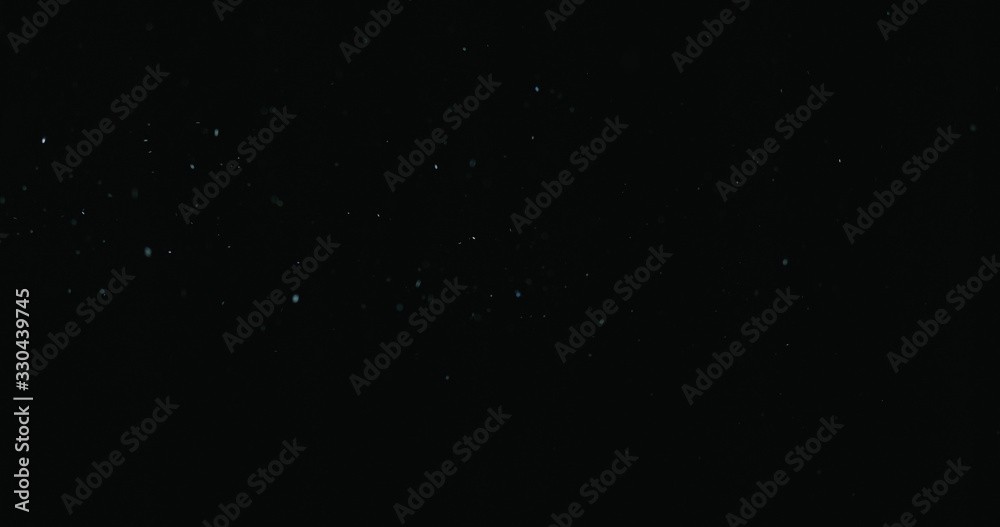 natural dust particles float in air on black background natural dust particles float in air on black background