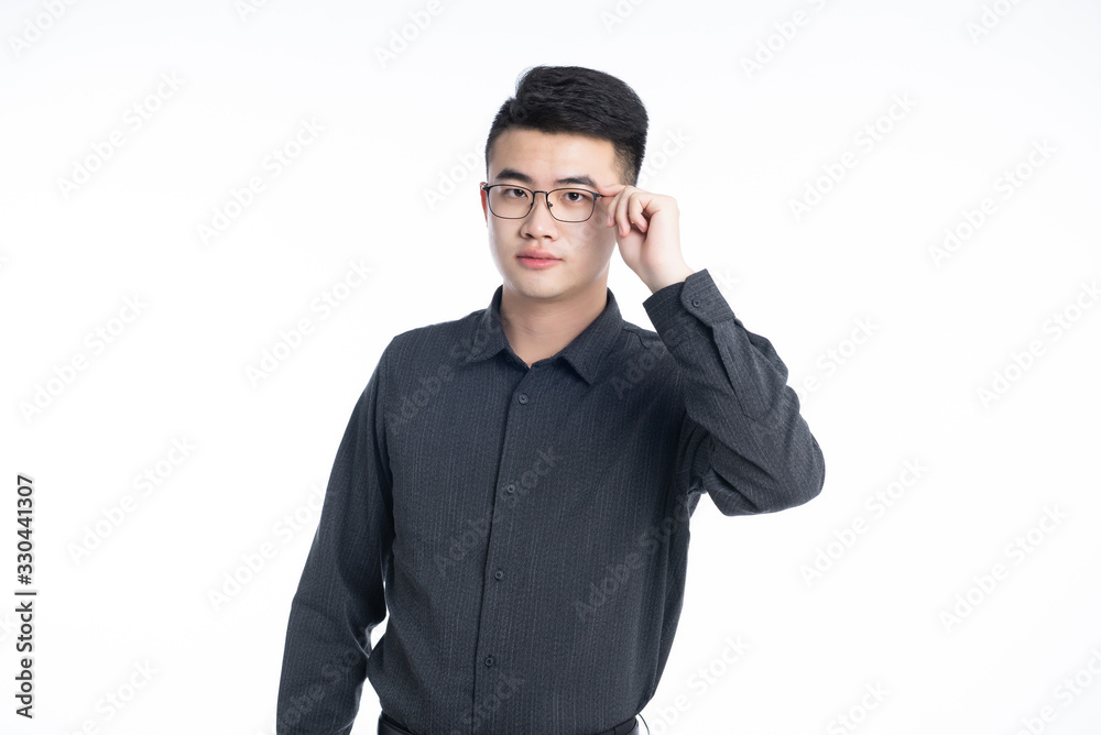 A young Asian business man stood behind his desk A young Asian business man stood behind his desk