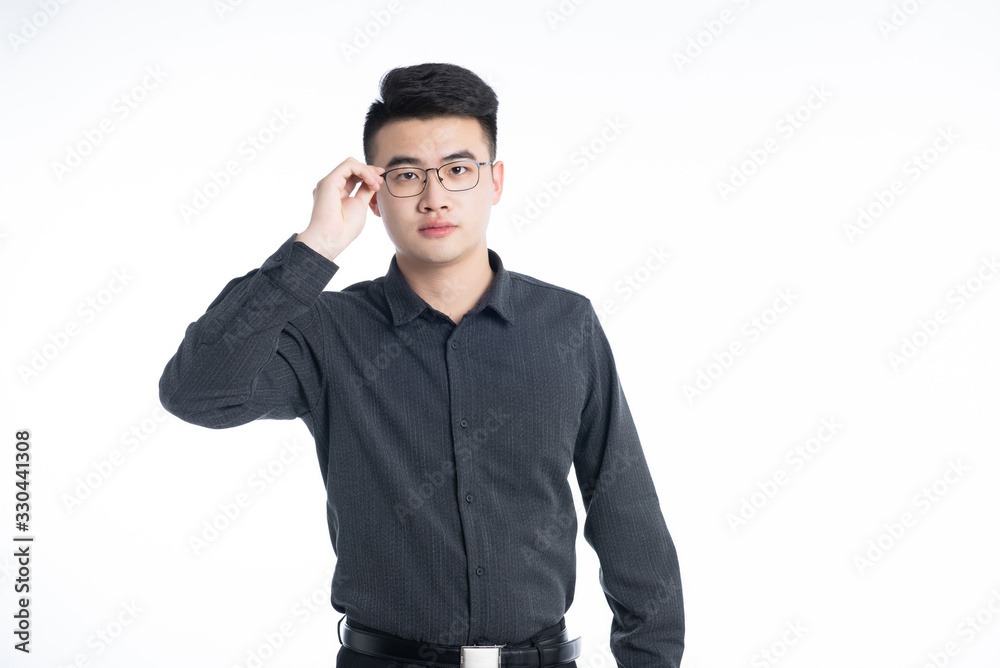 A young Asian business man stood behind his desk A young Asian business man stood behind his desk