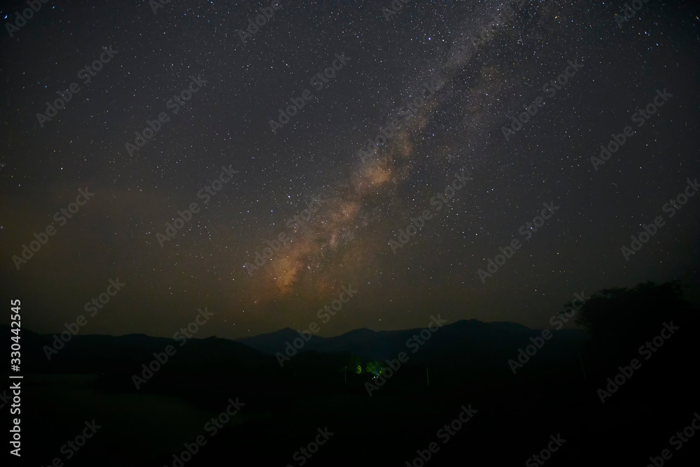 Landscape of the milky way galaxy with starlight over the mountain with tree at Kanchanaburi province,Thailand.
