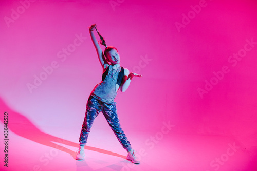 Young stylish girl dancing in the Studio on a colored neon background. Music dj poster design.