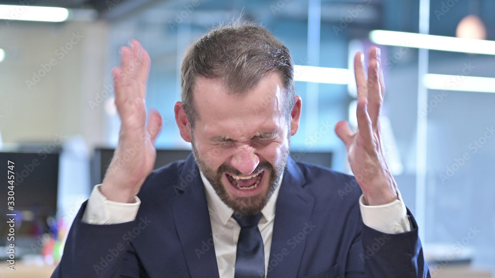 The Portrait of Angry Businessman Screaming Loud in Office