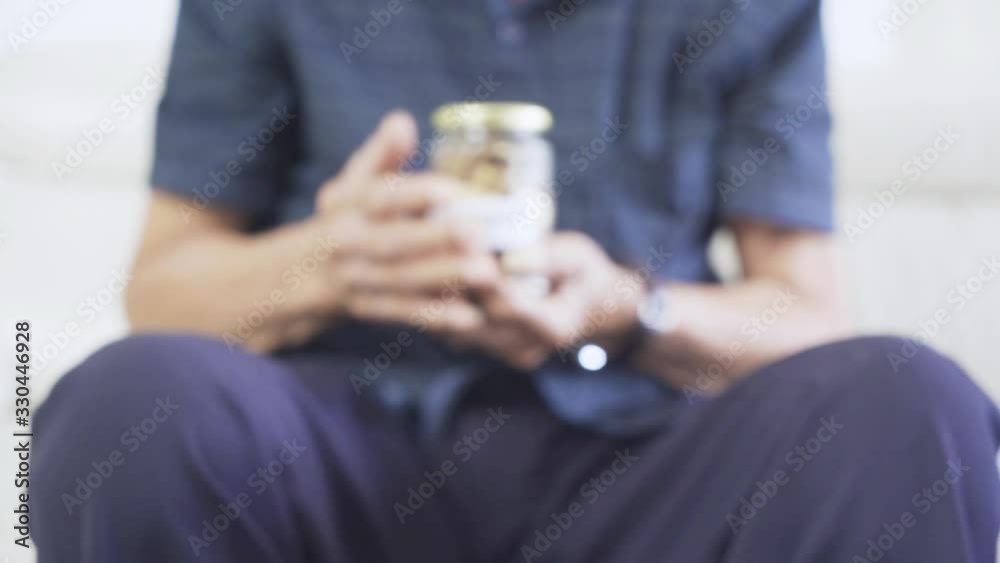 Elderly man hands holds glass jar with golden coins Elderly man hands holds glass jar with golden coins