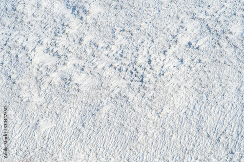 Background with snow tundra with snow-covered grass and bushes shot from above.