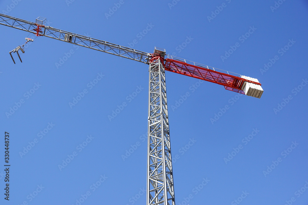 Part of a construction tower crane against the blue sky, copy space Part of a construction tower crane against the blue sky, copy space